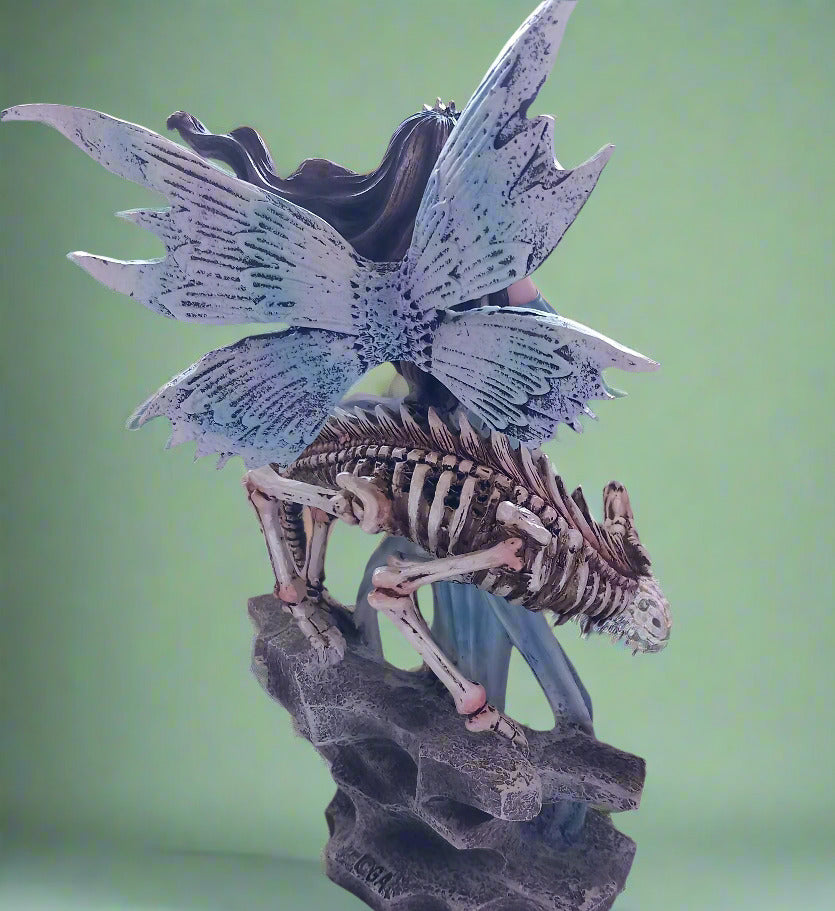 The back view of a blue fairy with wings and a skeleton dragon